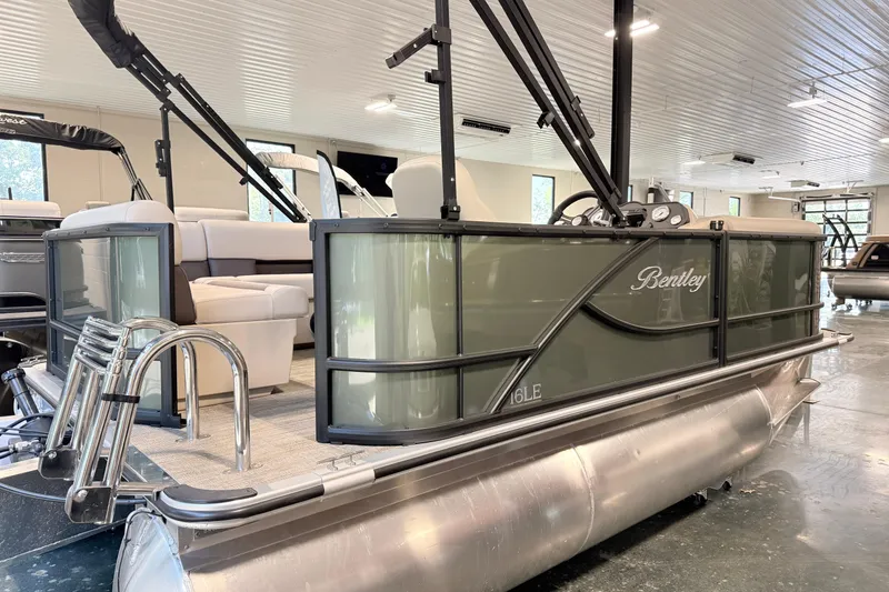 Slide: The Image of 2026 Bentley Pontoons LE 160 CR in showroom, featuring sleek design and luxurious seating. - 1