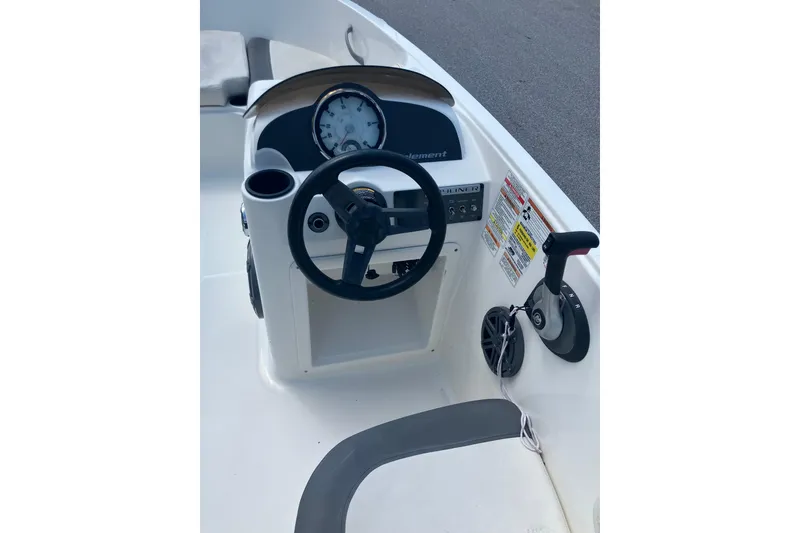Slide: The Image of 2018 Bayliner Element E16 boat dashboard with steering wheel and control panel. - 4