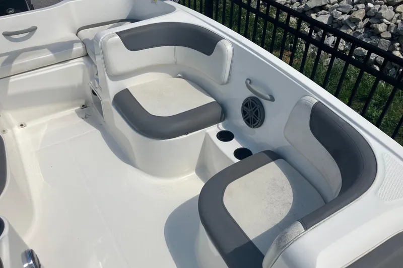 Slide: The Image of 2018 Bayliner Element E16 boat interior with gray and white seating, cup holders, and speaker. - 9