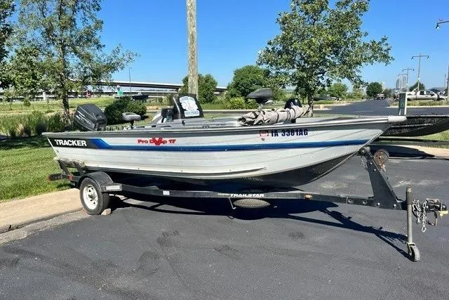 Slide: The Image of 1995 Bass Tracker Pro 17 boat on trailer, parked outdoors on a sunny day. - 11