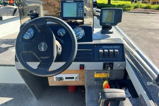 Slide: The Image of 1995 Bass Tracker Pro 17 boat dashboard with steering wheel and electronic displays. - 5