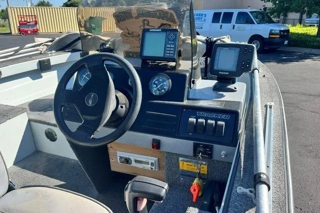 Slide: The Image of 1995 Bass Tracker Pro 17 boat dashboard with steering wheel and electronic displays. - 3