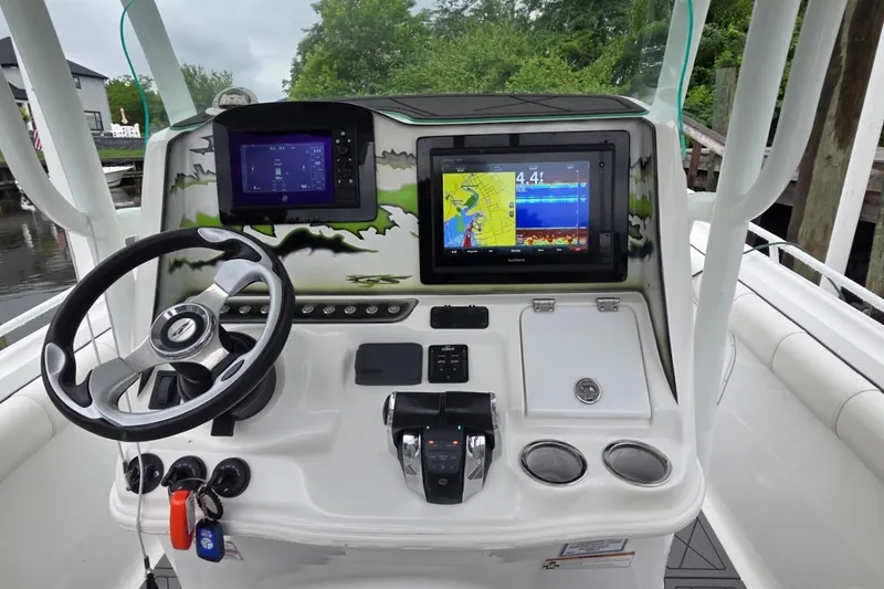 Slide: The Image of 2019 Glasstream 328 SCX boat dashboard with navigation screens and steering wheel. - 7