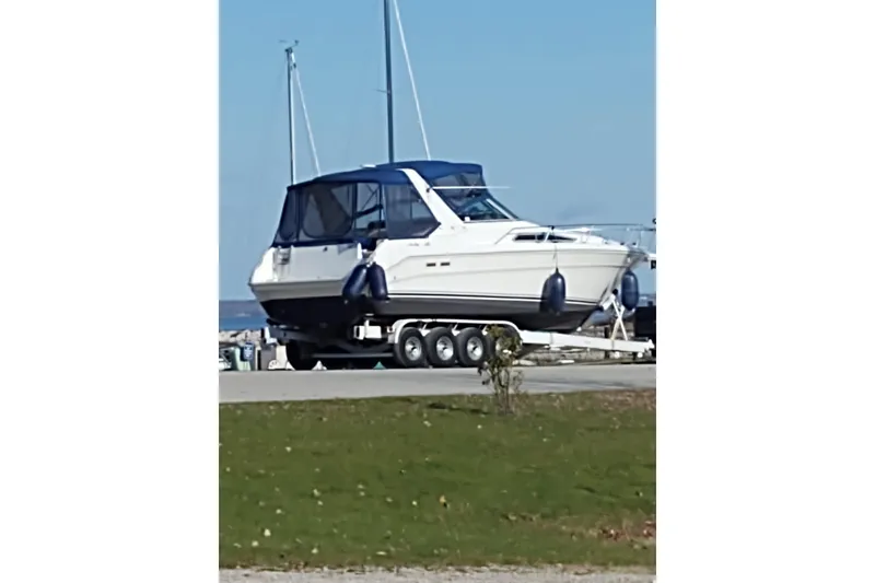 Slide: The Image of 1993 Sea Ray Sundancer 330 boat on trailer, parked near waterfront. - 32