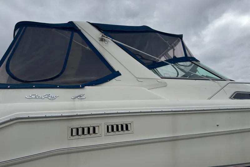 Slide: The Image of 1993 Sea Ray Sundancer 330 boat with blue canopy under cloudy sky. - 3