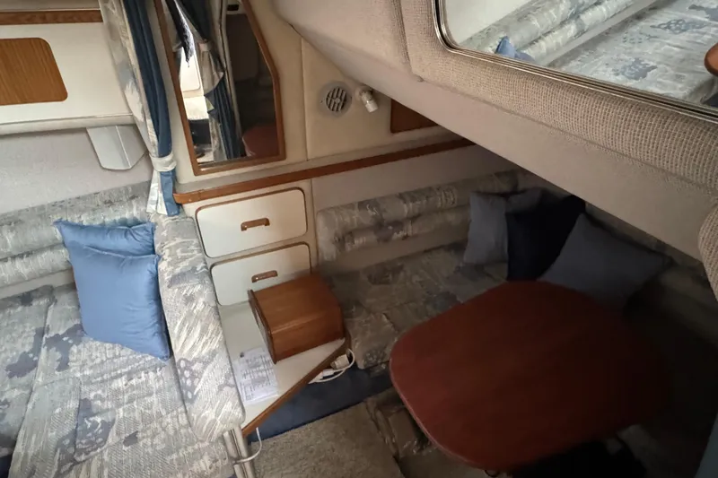 Slide: The Image of Interior of 1993 Sea Ray Sundancer 330, featuring cozy seating and wooden table. - 29