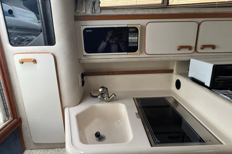 Slide: The Image of 1993 Sea Ray Sundancer 330 galley with sink, stove, and microwave. - 21