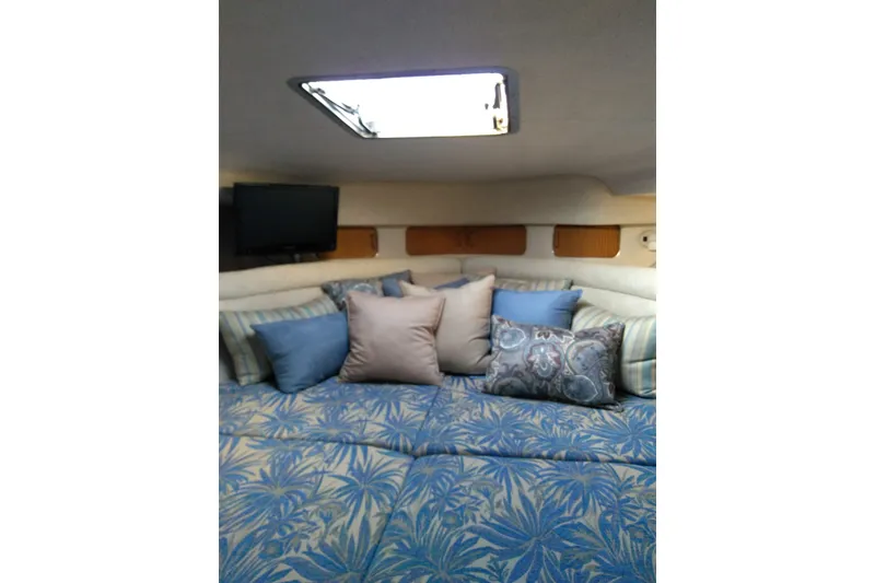 Slide: The Image of Cozy cabin interior of 1993 Sea Ray Sundancer 330 with patterned bedding and pillows. - 14