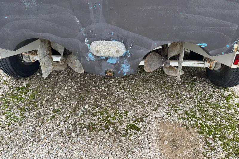 Slide: The Image of Rear view of a 1993 Sea Ray Sundancer 330 boat on gravel, showing propellers. - 31