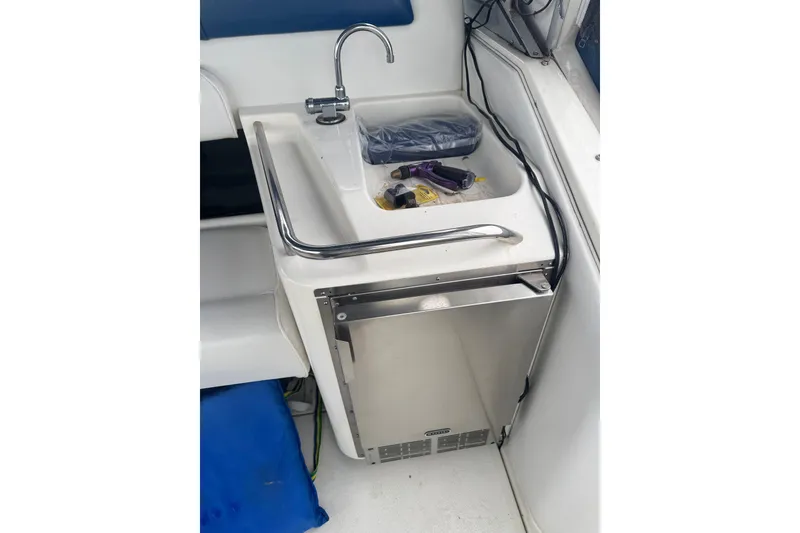 Slide: The Image of Compact kitchenette on 1993 Sea Ray Sundancer 330 boat with sink and mini fridge. - 12