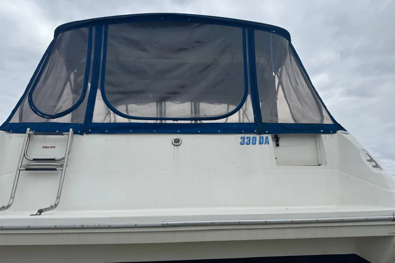 Slide: The Image of 1993 Sea Ray Sundancer 330 boat with blue canopy and ladder, rear view. - 2