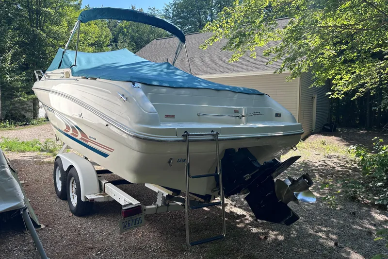 Slide: The Image of 1998 Sea Ray 260 Signature boat on trailer with blue cover, parked outdoors. - 5