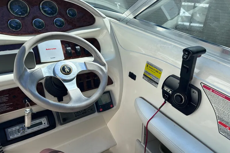 Slide: The Image of Interior view of a 1998 Sea Ray 260 Signature boat dashboard with steering wheel and controls. - 14