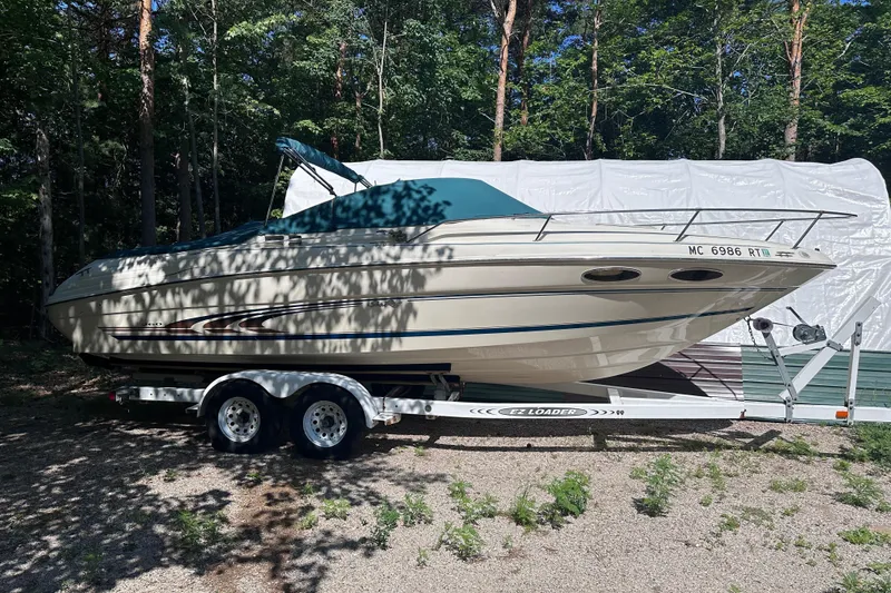 Slide: The Image of 1998 Sea Ray 260 Signature boat on trailer, surrounded by trees. - 3