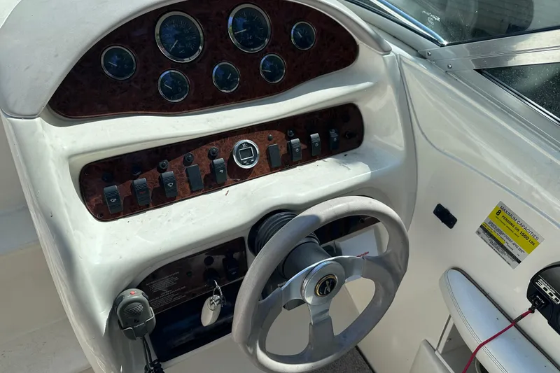 Slide: The Image of 1998 Sea Ray 260 Signature boat dashboard with steering wheel and control panel. - 12