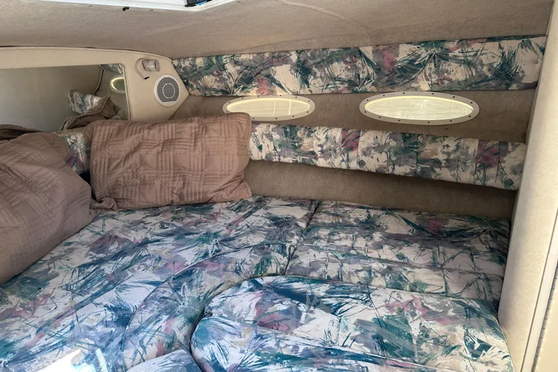 Slide: The Image of Interior cabin of 1998 Sea Ray 260 Signature with patterned upholstery and pillows. - 19