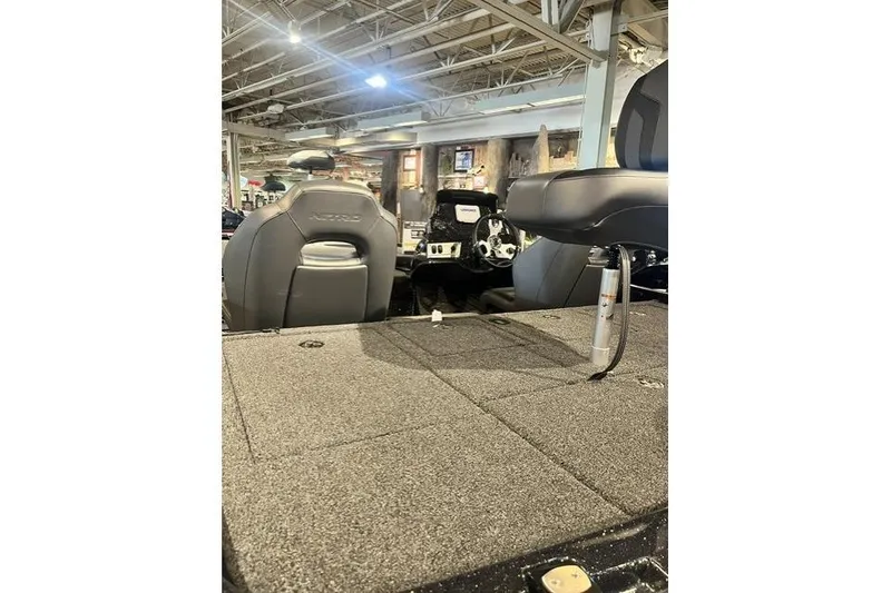 The Image of 2026 Nitro Z19 XL boat interior with seating and steering wheel in showroom. - 1