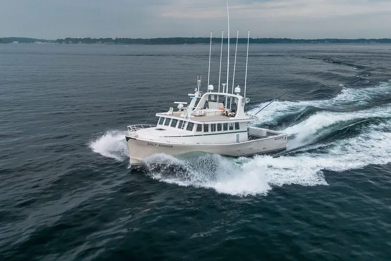 Slide: The Image of A 2018 Dixon 55 boat named "Salt Shaker" cruising swiftly on open water. - 10