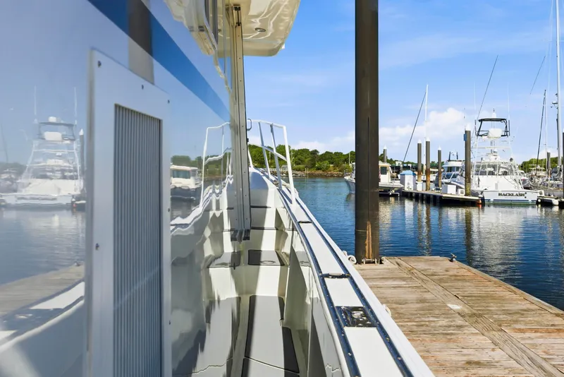 Slide: The Image of Side view of a 2018 Dixon 55 yacht docked at a marina under clear blue skies. - 27