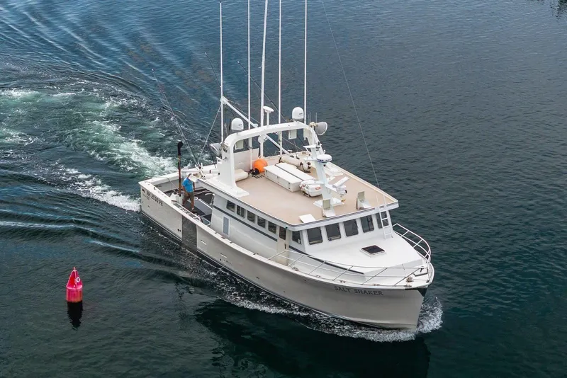 Slide: The Image of A 2018 Dixon 55 boat cruising on calm waters near a red buoy. - 12