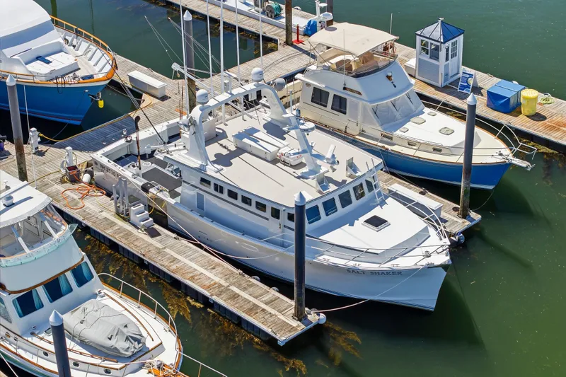 Slide: The Image of Docked Dixon 55 boat from 2018, surrounded by other vessels in a marina. - 8