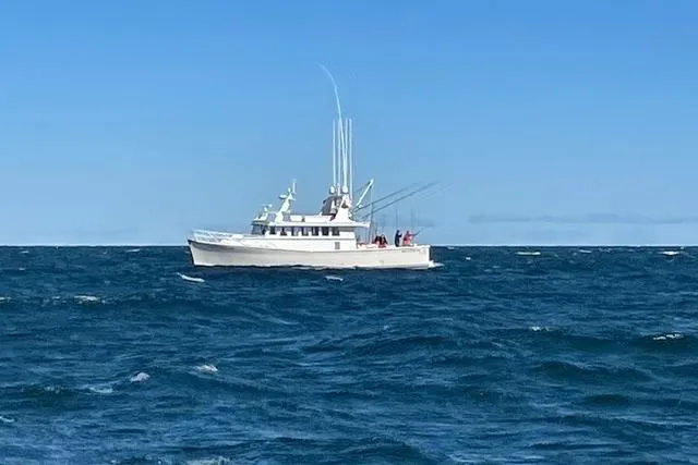 Slide: The Image of A 2018 Dixon 55 boat navigating the ocean under a clear blue sky. - 17