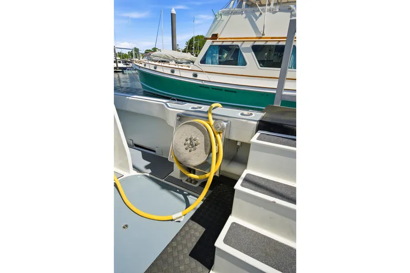 Slide: The Image of Dixon 55 boat, 2018 model, docked with visible yellow hose and steps. - 63