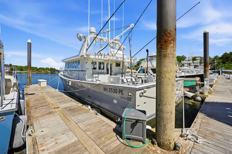 Slide: The Image of Docked Dixon 55 boat from 2018, moored at a sunny marina with clear skies. - 3