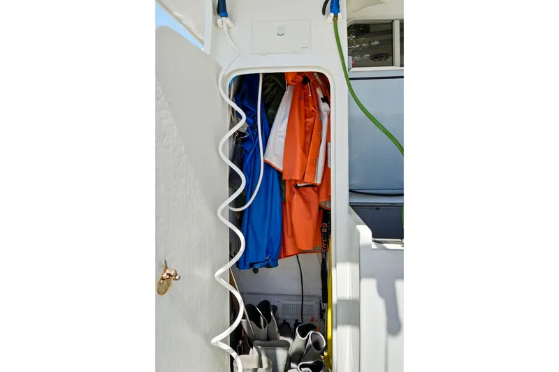 Slide: The Image of Storage compartment on a 2018 Dixon 55 boat with jackets and boots. - 60