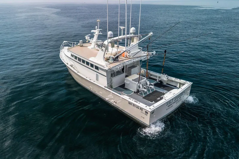 Slide: The Image of 2018 Dixon 55 boat cruising on open water, equipped for fishing. - 13