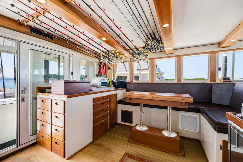Slide: The Image of Interior of 2018 Dixon 55 boat with fishing rods, seating, and wooden cabinetry. - 38