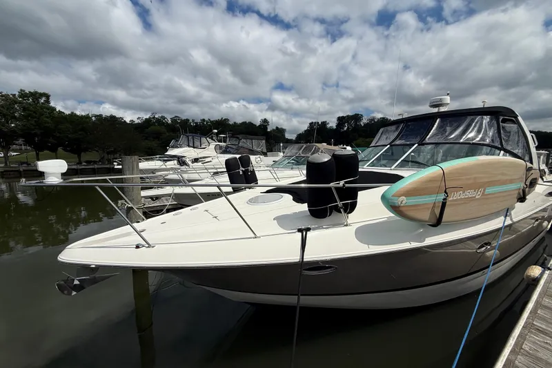 Slide: The Image of 2006 Cruisers Yachts 370 Express docked with paddleboard on deck under cloudy sky. - 1