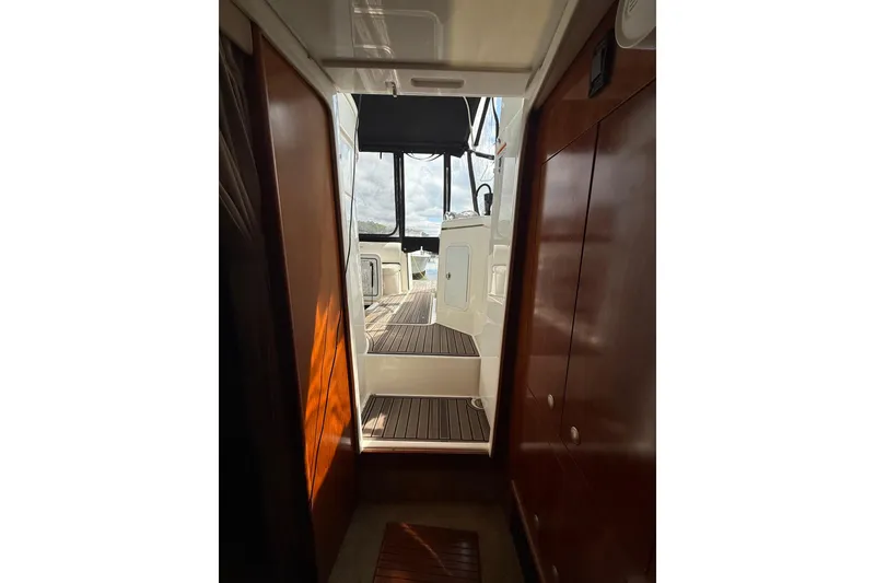 Slide: The Image of Interior view of 2006 Cruisers Yachts 370 Express, showcasing wooden cabinetry and deck access. - 21