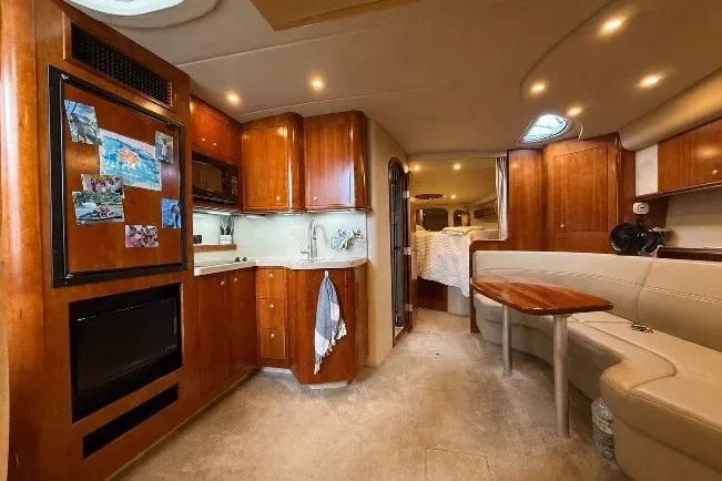 Slide: The Image of Luxurious 2006 Cruisers Yachts 370 Express interior with wood cabinetry and cozy seating area. - 22