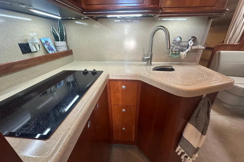 Slide: The Image of 2006 Cruisers Yachts 370 Express kitchen with sleek countertop, stove, and modern faucet. - 25