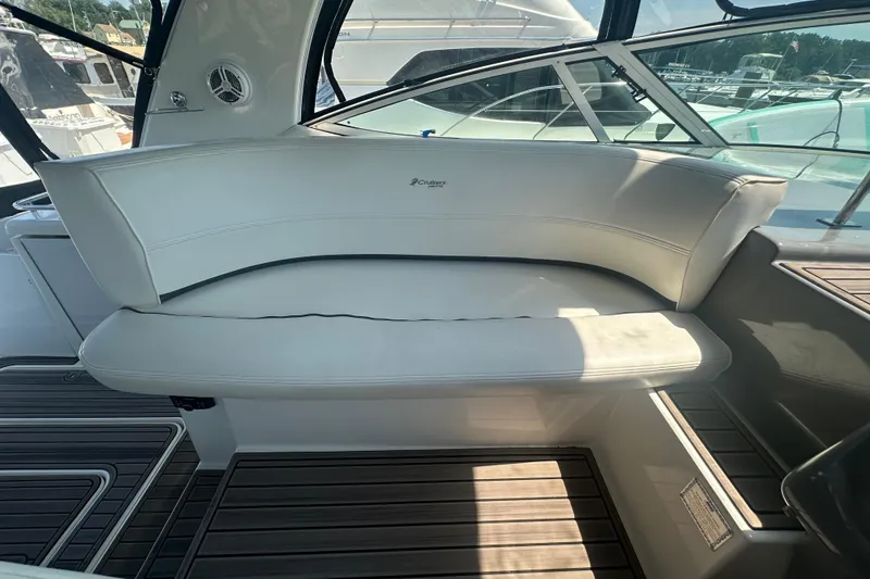 Slide: The Image of 2006 Cruisers Yachts 370 Express interior seating with white upholstery and wood flooring. - 10