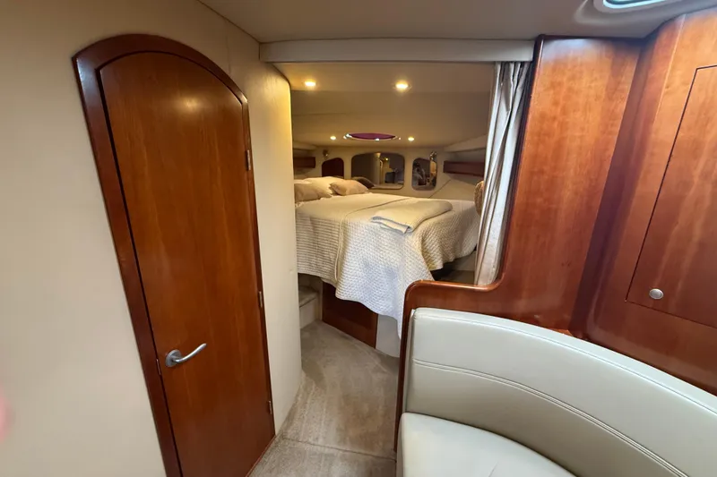 Slide: The Image of Interior of 2006 Cruisers Yachts 370 Express, featuring cozy cabin with bed and wooden accents. - 29