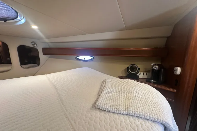 Slide: The Image of 2006 Cruisers Yachts 370 Express cabin interior with bed, porthole, and coffee maker. - 36