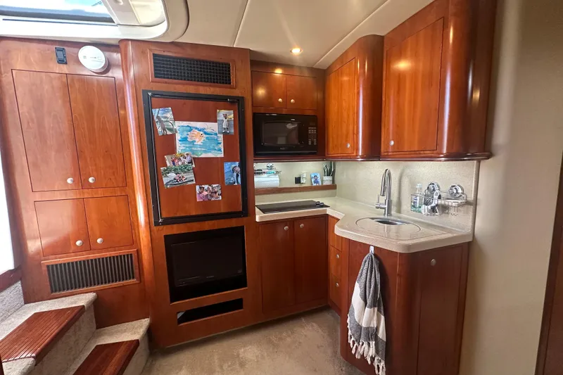 Slide: The Image of Luxurious 2006 Cruisers Yachts 370 Express kitchen with wood cabinetry and modern appliances. - 27