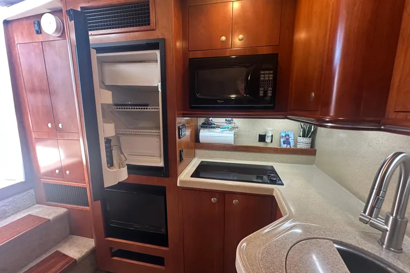 Slide: The Image of 2006 Cruisers Yachts 370 Express kitchen with fridge, microwave, and stove. - 26