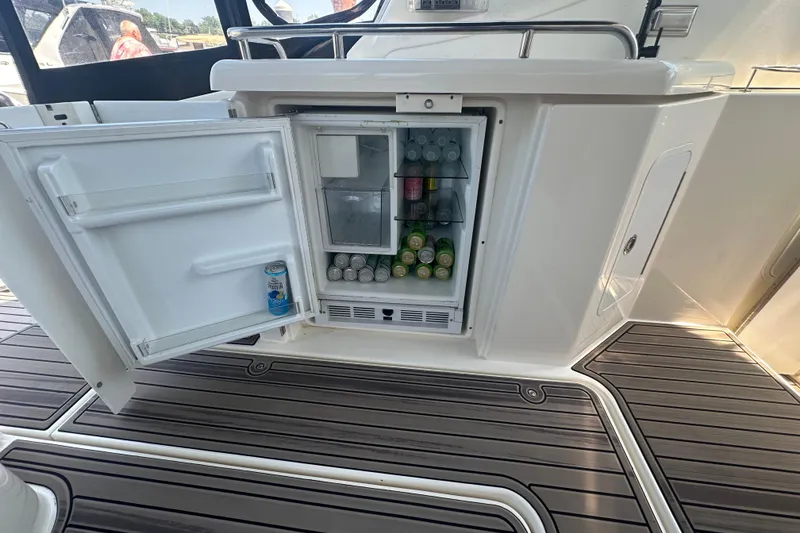 Slide: The Image of Open mini fridge on 2006 Cruisers Yachts 370 Express, stocked with beverages on deck. - 15