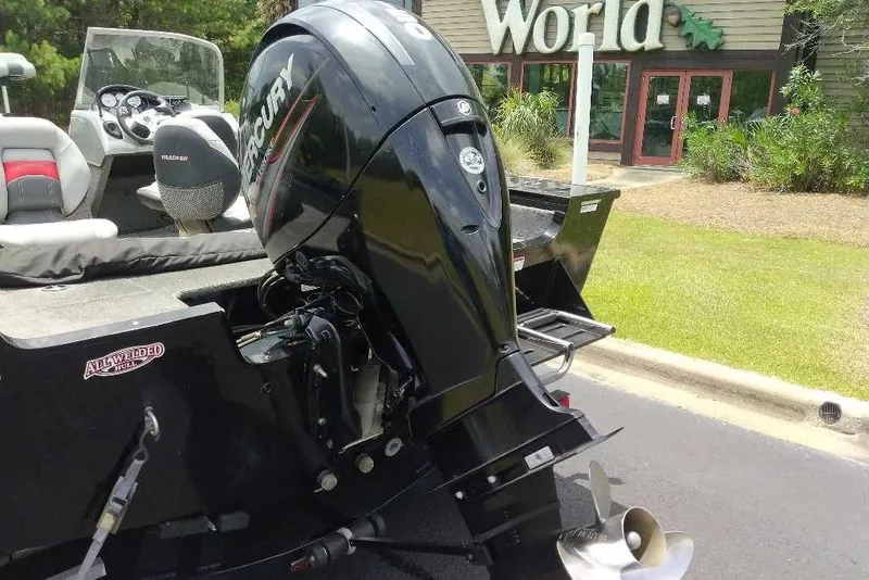 Slide: The Image of 2015 Tracker Targa V-18 WT boat with Mercury outboard motor, parked near a building. - 10