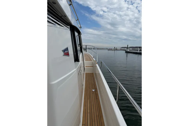 Slide: The Image of Side view of 2025 Nimbus 365 Coupe yacht with wooden deck and calm waters. - 18