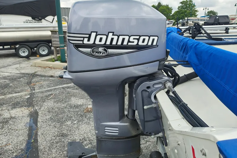 Slide: The Image of 1999 LOWE BOATS SEA NYMPH V-148SC with Johnson outboard motor in a parking lot. - 15