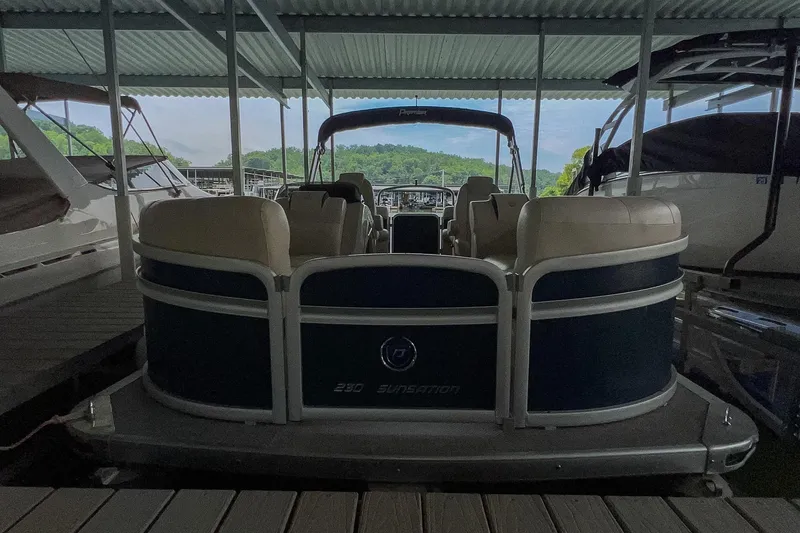 Slide: The Image of 2020 Premier 230 Sunsation pontoon boat docked under a covered marina. - 24