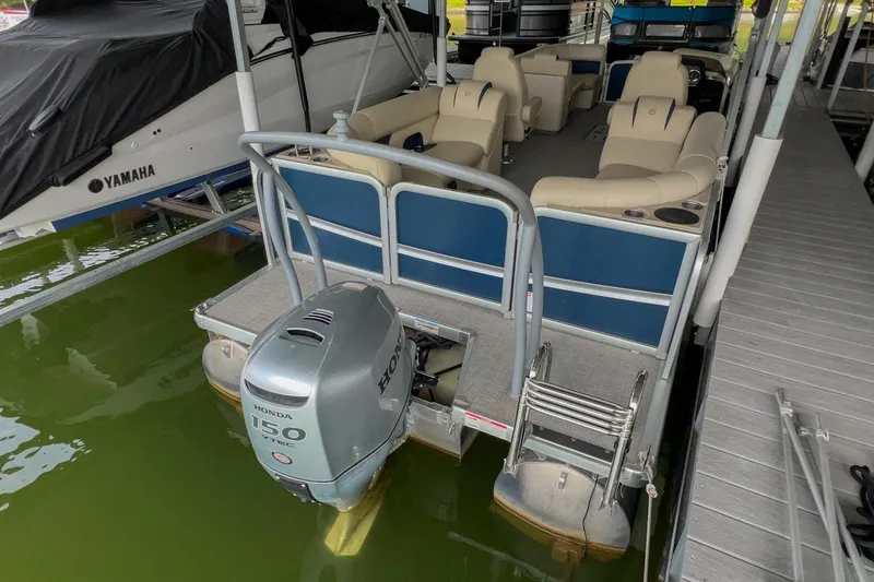 Slide: The Image of 2020 Premier 230 Sunsation pontoon boat with Honda 150 engine docked in marina. - 25