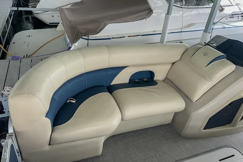 Slide: The Image of Luxurious seating on a 2020 Premier 230 Sunsation pontoon boat, featuring beige and blue upholstery. - 29