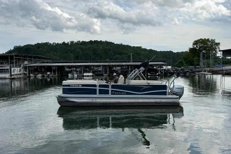 The Image of 2020 Premier 230 Sunsation pontoon boat on a calm lake near a marina. - 5