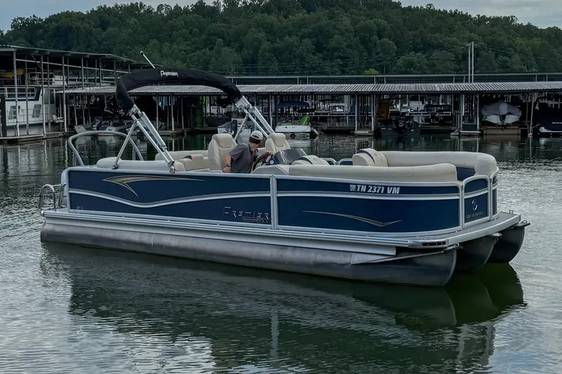 Slide: The Image of 2020 Premier 230 Sunsation pontoon boat docked on a calm lake. - 21