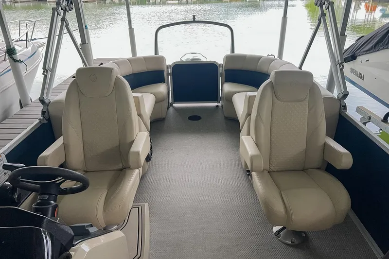 Slide: The Image of 2020 Premier 230 Sunsation pontoon boat interior with beige seating and steering wheel. - 31